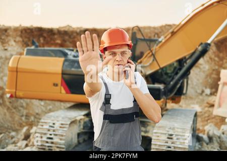 Porträt eines Arbeiters in Berufsuniform, der tagsüber auf der Leihgrube steht Stockfoto