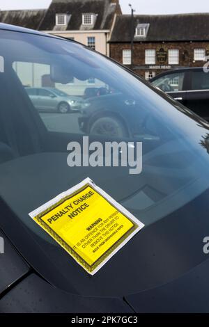 Hinweis auf Strafgebühren an der Windschutzscheibe eines auf einem Parkplatz geparkten Autos. Stockfoto