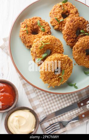 Hähnchen-Donuts werden aus einer Mischung aus Hackfleisch, gekochten Kartoffeln, Zwiebeln und Karotten auf dem Teller auf dem Tisch hergestellt. Vertikale Draufsicht Stockfoto