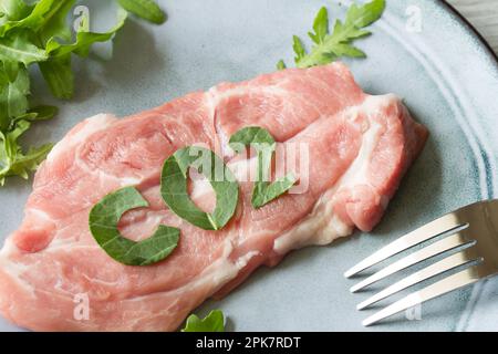 Fleischproduktion und globales Problem mit Emissionen CO2, CO2-Fußabdruck-Konzept mit Schweinesteak auf dem Teller Stockfoto