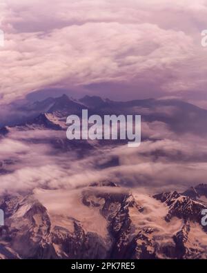 Luftaufnahme von einer dünnen Schicht von Monsun Wolken über die schneebedeckten Gipfel der Dhauladhar/Weiße Palette von Lesser Himalaya in Indien. Stockfoto