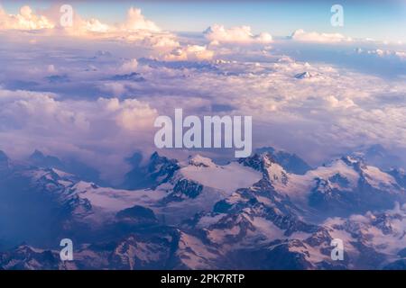 Luftaufnahme von einer dünnen Schicht von Monsun Wolken über die schneebedeckten Gipfel der Dhauladhar/Weiße Palette von Lesser Himalaya in Indien. Stockfoto