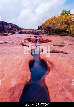 Ein Bach, der einen Pfad durch dickes Gestein ausgräbt. Foto aufgenommen im Kharmih Park, Sohra/Cherrapunjee, Meghalaya, Indien. Stockfoto