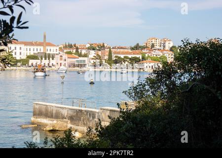 ROVINJ, KROATIEN - 15. MAI 2022 die Altstadt aus der Ferne gesehen zwischen den Tees mit klarem blauem Wasser Stockfoto