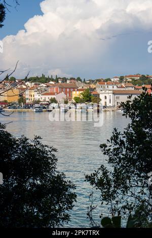 ROVINJ, KROATIEN - 15. MAI 2022 die Altstadt aus der Ferne gesehen zwischen den Tees mit klarem blauem Wasser Stockfoto