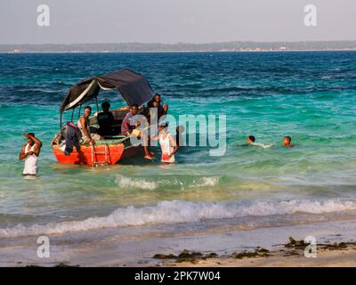 Sansibar, Tansania - Jan, 2021: Boot mit einer Gruppe afrikanischer Männer, die auf Prison Island (auch bekannt als Changuu, Quarantine Island i Kibandiko) festmachen. Heute Stockfoto