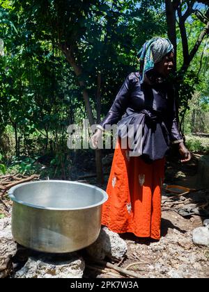 Sansibar, Tansania - Januar 2021: Portrait einer afrikanischen Frau, die am Feuer kocht. Afrika Stockfoto