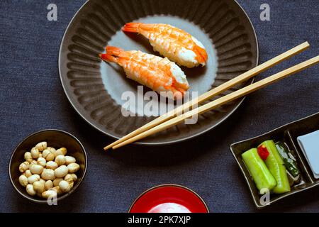 Garnelen und Reis auf einem blauen Gericht mit Stäbchen. Stockfoto