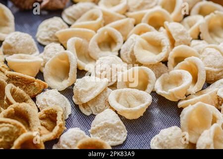 Frische Orekchiette oder Orekchietta aus Hartweizen und Wasser, handgemachte Pasta, typisch für Apulien oder Apulien, eine Region Süditaliens, aus nächster Nähe Stockfoto
