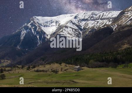 Blick auf die Sternennacht über den schneebedeckten Bergen in der Region Marken in Italien Stockfoto