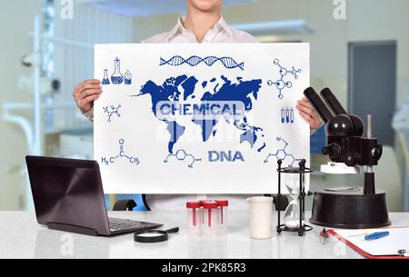 Wissenschaftlerin im Labor und Poster mit chemischem Symbol in der Hand Stockfoto