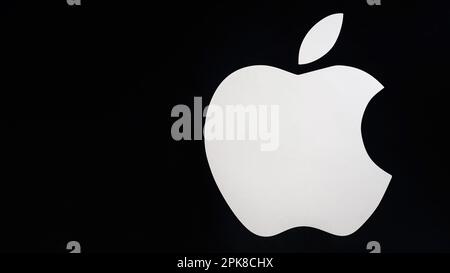 SHYMKENT, KAZAKHSAN - 23. JANUAR 2023: Apple-Logo auf schwarzem Hintergrund an der Wand eines Elektronikgeschäfts Stockfoto