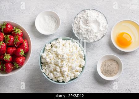 Zutaten für hausgemachten Hüttenkäse-Gnocchi mit Erdbeersauce: Hüttenkäse, Erdbeere, Reismehl, Ei, Zucker, Vanillezucker, Backpulver Stockfoto