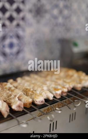 Saftiges Schweinefleisch gegrillt in einer elektrischen Pfanne in einem Fast-Food-Restaurant Stockfoto