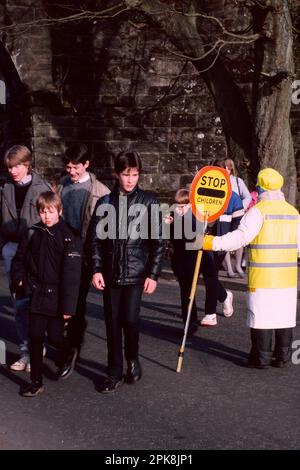 Kinder, die die Straße überqueren, bei der Schülerpatrouille, Helensburgh, Schottland Stockfoto