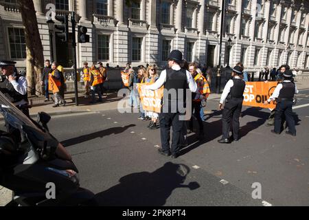 Aktivisten von „Just Stop Oil“ versuchen, ein Banner vor dem Verkehr in Westminster im Zentrum von London zu halten. Stockfoto