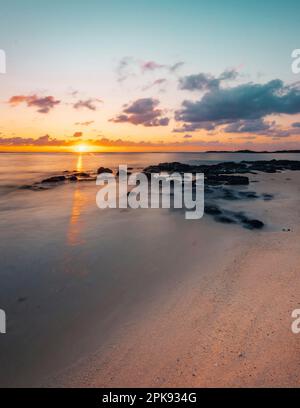 Sandstrand aus heiterem Himmel im Osten von Mauritius. Wunderschöner natürlicher Sandstrand am Morgen. Sonnenaufgang am Trou díEau Douce Stockfoto