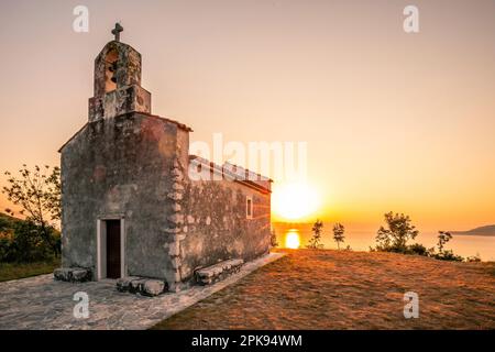 Wunderschöne kleine kroatische Kirche im Dorf Brsec, die Kirche St. Maria Magdalena auf einer Klippe über dem Meer in Istrien, Kroatien bei Sonnenaufgang Stockfoto