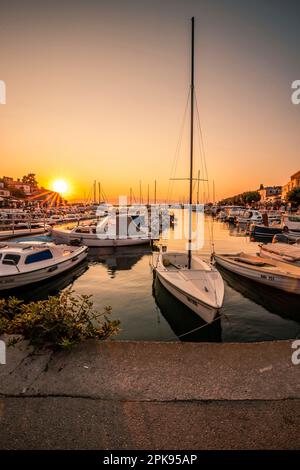 Sonnenuntergang über dem Hafen und der Altstadt von Krk auf der Urlaubsinsel Krk in Kroatien am Mittelmeer Stockfoto