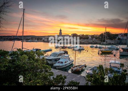 Sonnenuntergang über dem Hafen und der Altstadt von Krk auf der Urlaubsinsel Krk in Kroatien am Mittelmeer Stockfoto