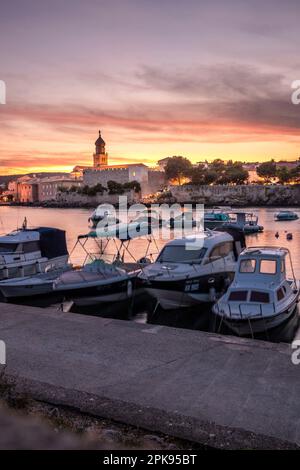 Sonnenuntergang über dem Hafen und der Altstadt von Krk auf der Urlaubsinsel Krk in Kroatien am Mittelmeer Stockfoto