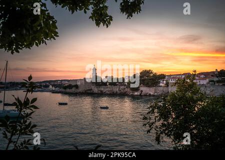 Sonnenuntergang über dem Hafen und der Altstadt von Krk auf der Urlaubsinsel Krk in Kroatien am Mittelmeer Stockfoto