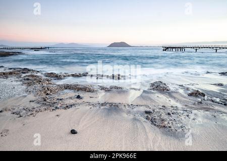 Wunderschöner Morgen am Sandstrand. Lange Exposition am Meer. Milchiger Sonnenaufgang in Nebel und Dunst. Corralejo, Kanarische Inseln, Spanien Stockfoto