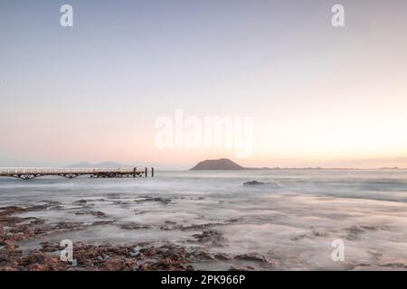 Wunderschöner Morgen am Sandstrand. Lange Exposition am Meer. Milchiger Sonnenaufgang in Nebel und Dunst. Corralejo, Kanarische Inseln, Spanien Stockfoto