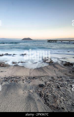 Wunderschöner Morgen am Sandstrand. Lange Exposition am Meer. Milchiger Sonnenaufgang in Nebel und Dunst. Corralejo, Kanarische Inseln, Spanien Stockfoto