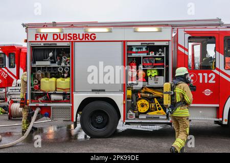 Duisburg, Nordrhein-Westfalen, Deutschland - Feuerwehrübung, Menschen werden aus einer brennenden Wohnung gerettet. Der Feuerwehrmann kommt nach der Operation zurück zum Feuerwehrwagen. Presseveranstaltung: Bundeskanzler Olaf Scholz besucht die Feuerwehreinheit 530 der Duisburger Freiwilligenfeuerwehr in der Feuerwehr- und Rettungsstation 5 in Homberg. Neben einer Feuerwehreinheit der Berufsfeuerwehr befindet sich dort auch die Feuerwehrschule. Stockfoto