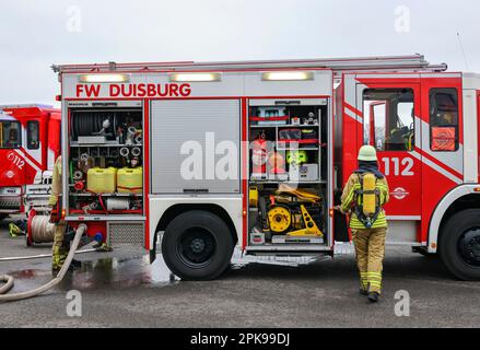 Duisburg, Nordrhein-Westfalen, Deutschland - Feuerwehrübung, Menschen werden aus einer brennenden Wohnung gerettet. Der Feuerwehrmann kommt nach der Operation zurück zum Feuerwehrwagen. Presseveranstaltung: Bundeskanzler Olaf Scholz besucht die Feuerwehreinheit 530 der Duisburger Freiwilligenfeuerwehr in der Feuerwehr- und Rettungsstation 5 in Homberg. Neben einer Feuerwehreinheit der Berufsfeuerwehr befindet sich dort auch die Feuerwehrschule. Stockfoto