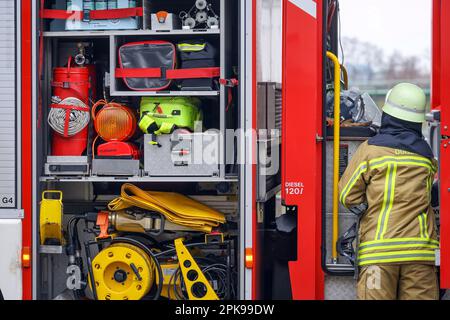 Duisburg, Nordrhein-Westfalen, Deutschland - Feuerwehrübung, Menschen werden aus einer brennenden Wohnung gerettet. Der Feuerwehrmann kommt nach der Operation zurück zum Feuerwehrwagen. Presseveranstaltung: Bundeskanzler Olaf Scholz besucht die Feuerwehreinheit 530 der Duisburger Freiwilligenfeuerwehr in der Feuerwehr- und Rettungsstation 5 in Homberg. Neben einer Feuerwehreinheit der Berufsfeuerwehr befindet sich dort auch die Feuerwehrschule. Stockfoto