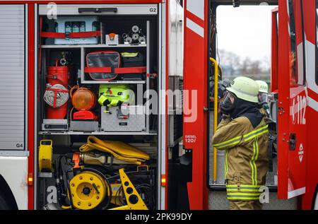 Duisburg, Nordrhein-Westfalen, Deutschland - Feuerwehrübung, Menschen werden aus einer brennenden Wohnung gerettet. Der Feuerwehrmann kommt nach der Operation zurück zum Feuerwehrwagen. Presseveranstaltung: Bundeskanzler Olaf Scholz besucht die Feuerwehreinheit 530 der Duisburger Freiwilligenfeuerwehr in der Feuerwehr- und Rettungsstation 5 in Homberg. Neben einer Feuerwehreinheit der Berufsfeuerwehr befindet sich dort auch die Feuerwehrschule. Stockfoto