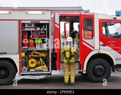 Duisburg, Nordrhein-Westfalen, Deutschland - Feuerwehrübung, Menschen werden aus einer brennenden Wohnung gerettet. Der Feuerwehrmann kommt nach der Operation zurück zum Feuerwehrwagen. Presseveranstaltung: Bundeskanzler Olaf Scholz besucht die Feuerwehreinheit 530 der Duisburger Freiwilligenfeuerwehr in der Feuerwehr- und Rettungsstation 5 in Homberg. Neben einer Feuerwehreinheit der Berufsfeuerwehr befindet sich dort auch die Feuerwehrschule. Stockfoto