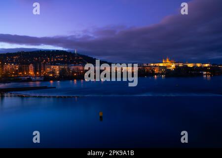 Traumhafter Nachtsicht auf die Prager Burg von der Moldau mit magischem Himmel und Lichtern von den Straßen am Abend in der Altstadt. Stockfoto