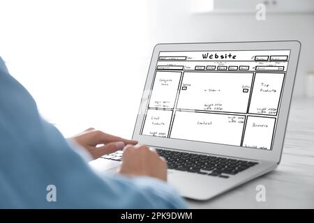 Designer erstellt Website auf Laptop am weißen Tisch, Nahaufnahme Stockfoto