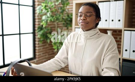 Eine afroamerikanische Geschäftsfrau, die Yoga-Übungen im Büro macht Stockfoto
