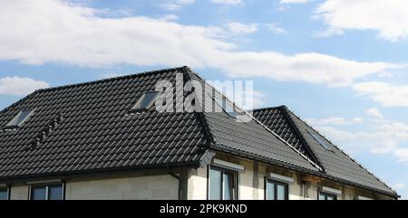 Unfertige Häuser mit schwarzem Dach am blauen Himmel Stockfoto