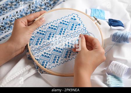 Besticktes Frauenhemd mit blauem Faden, Nahaufnahme. Ukrainische Nationalkleidung Stockfoto