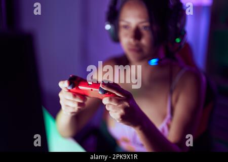 Junge hispanische Frau streamer spielt Videospiel im Spielsalon Stockfoto