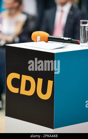 10.02.2023, Deutschland, Berlin, Berlin - Ein Stehpult mit dem Logo der CDU im Konrad-Adenauer-Haus. Ein Mikrofon und ein Wasserglas liegen auf dem auf Stockfoto
