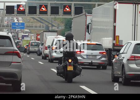 19.08.2022, Deutschland, Brandenburg, Michendorf - Motorradfahrer, der während eines Staus auf dem Berliner Ring auf der Notspur fährt. 00S220819D13 Stockfoto