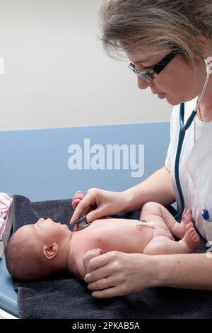 Der Kinderarzt überprüft die Herzfrequenz des Neugeborenen. Stockfoto