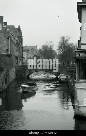 Ein Touristenboot fährt über den Blinde-Ezelbrug auf dem Groenerei-Kanal in Brügge, Belgien Stockfoto