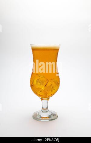 Ein Glas Bier mit Wassertröpfchen auf weißem Hintergrund. Stockfoto