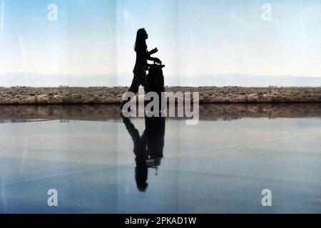 25.02.2023, Katar, , Doha - Silhouette: Reisende im Terminal des internationalen Flughafens Hamad. 00S230225D382CAROEX.JPG [MODELLVERSION: JA, RICHTIG Stockfoto