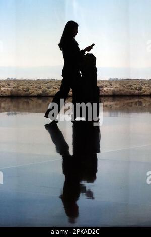 25.02.2023, Katar, , Doha - Silhouette: Passagiere im Terminal des internationalen Flughafens Hamad. 00S230225D411CAROEX.JPG [MODELLVERSION: JA, RICHTIG Stockfoto