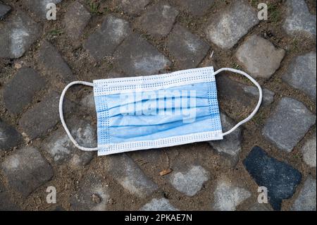 23.11.2022, Deutschland, Berlin - Europa - Ein gebrauchter und ausrangierter Corona (Covid-19) Mundschutz liegt auf dem Boden. 0SL221123D003CAROEX.JPG [MODELLVERSION Stockfoto