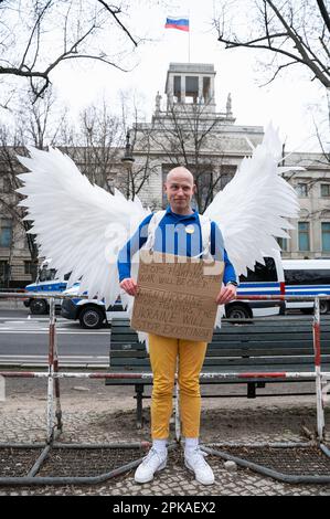 24.02.2023, Deutschland, Berlin - Europa - Friedensengel Jonas Schmidt demonstriert gegen den anhaltenden Krieg mit Engelsflügeln und einem Protestzeichen auf der Stockfoto