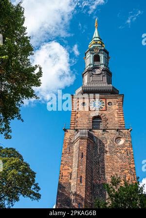 Kopenhagen, Dänemark - 13. September 2010: Sankt Petri Kirke, Kirche, roter Backsteinturm mit grünem Turm, vor blauem Himmel. Goldene Ornamente und Uhr, Stockfoto